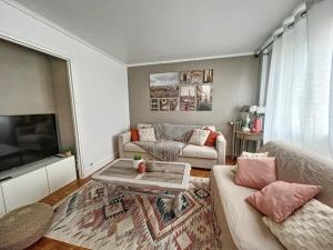 a living room with a couch and a table at Good vibes only apparts "So sweet"- 4 bedrooms - 8 pax - free Parking in Épinay-sur-Seine