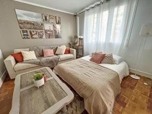 a living room with two beds and a couch at Good vibes only apparts "So sweet"- 4 bedrooms - 8 pax - free Parking in Épinay-sur-Seine