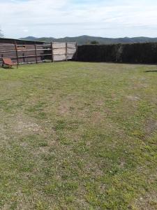 a large grass field with a fence in the background at Villetta a schiera nei pressi del mare in Livorno