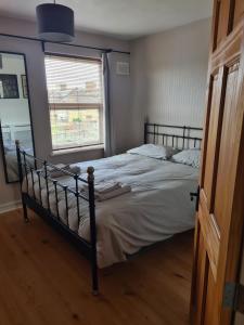 a bedroom with a bed and a window at Comfortable House in South East London in London