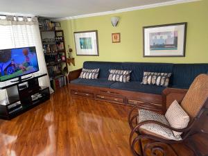 a living room with a blue couch and a tv at CHARLIE'S HOUSE in Bogotá