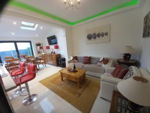 a living room with a couch and a table at Luxury holiday home, near beach in Southend-on-Sea
