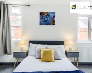 een slaapkamer met een bed met een geel kussen erop bij LOWest rate 6 Bedroom House 6 Bath in Coventry - City Centre with garden and FREE wi-fi- RRC in Coventry