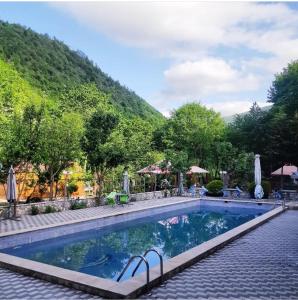a swimming pool at a resort with a mountain in the background at ECOHOTEL ''QIZIL Dere'' 