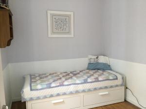een klein bed in een kamer met een muur bij Villa des sables in Duinkerke