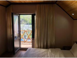 a bedroom with a bed and a door to a balcony at ECOHOTEL ''QIZIL Dere'' 
