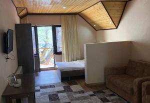 a living room with a couch and a bed at ECOHOTEL ''QIZIL Dere'' 