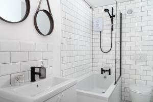 a white bathroom with a sink and a shower at Porthcurno Barns, The Big Barn - Spacious & cosy cottage, walk to Porthcurno beach, Pedn Vouder & Minack Theatre in Penzance +37 photos