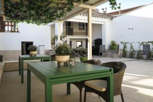 a green table and chairs in a patio at Tomé, Casa de Huéspedes in Orgaz