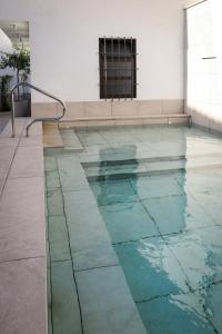 a swimming pool with blue water in a building at Tomé, casa de huéspedes in Orgaz
