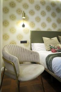 a bedroom with a bed and a chair and a wall at Tomé, casa de huéspedes in Orgaz