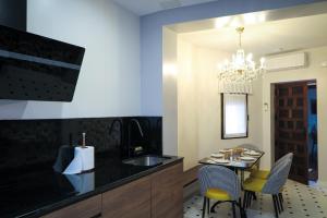 a kitchen with a sink and a table with chairs at Tomé, Casa de Huéspedes in Orgaz