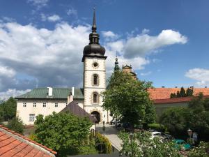 un gran edificio blanco con una torre de reloj en Noclegi U Bram Klasztoru, en Stary Sącz
