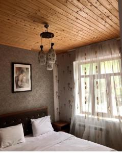 a bedroom with a bed with a wooden ceiling and a window at ECOHOTEL ''QIZIL Dere'' 