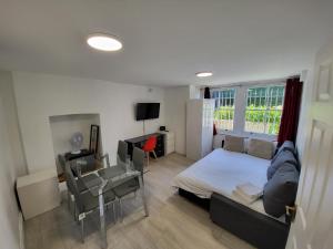 - une chambre avec un lit, une table et un bureau dans l'établissement Cosy Apartment By Clapham South Underground!, à Londres
