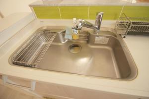 a sink with a strainer in a kitchen at Sea Breeze Sumuide 沖縄 in Nago