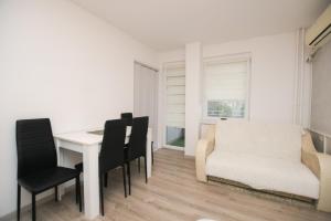 una sala da pranzo con tavolo bianco e sedie nere di Apartman Jana a Kladovo