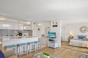 uma sala de estar com uma cama e uma cozinha com bancos em Ka Maluhia Suite, 1 Bed 1 Bath & 1 Free Parking em Honolulu