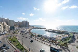 a view of a beach and the ocean with traffic at Lovely Seaview Condo in Saba Pasha in Alexandria