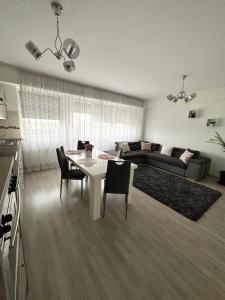 un soggiorno con tavolo e sedie bianchi di Class DeLuxe Apartments a Oradea
