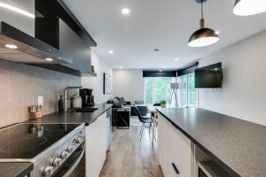 a kitchen with white cabinets and a counter top at Le PanoramiK by Gestion ELITE in Mont-Tremblant