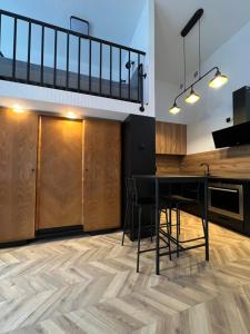 eine Küche mit einem schwarzen Tisch und Holzschränken in der Unterkunft I&M Apartments Rejtana Wrocław in Breslau