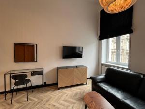 ein Wohnzimmer mit einem Sofa, einem Tisch und einem TV in der Unterkunft I&M Apartments Rejtana Wrocław in Breslau