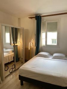1 dormitorio con 1 cama grande y espejo en Small studio paris 16 best location, en París