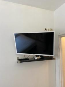 TV de pantalla plana colgada en la pared en Small studio paris 16 best location, en París