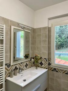 a bathroom with a sink and a mirror and a window at Villa Filippo in Cerliano