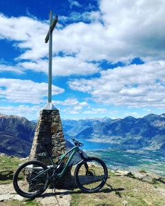 uma bicicleta estacionada ao lado de um poste no topo de uma montanha em MarAvilia Apartment, vicino al Monte Tamaro e al parco acquatico Splash & SPA em Monte Ceneri