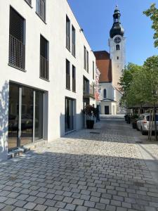 a cobblestone street in front of a building with a clock tower at Zimmer am Platz in Purgstall