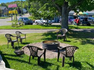 um grupo de cadeiras sentadas à volta de uma fogueira na relva em Scotty's Motel em Munising