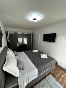 een slaapkamer met een groot bed en een televisie bij Apartment Adrian in Kaštela