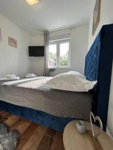 een slaapkamer met een bed met een blauw hoofdeinde en een tafel bij Apartment Adrian in Kaštela