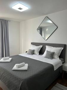 een slaapkamer met een groot bed met een spiegel aan de muur bij Apartment Adrian in Kaštela