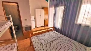 una camera da letto con un letto e una finestra con una tenda di Ramo's Cozy Beachside Haven with Panoramic Views - 1st a Vlorë