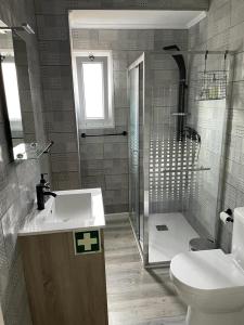 y baño con lavabo, ducha y aseo. en Casa Pyrrhula Murina - Private Jacuzzi, en Nordeste