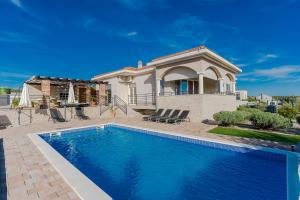 a house with a swimming pool in front of a house at Villa Luka in Zadar