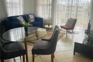 a living room with a glass table and chairs at 721 @ Leisure Bay in Pretoria