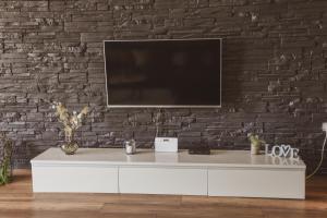 a living room with a tv on a brick wall at Apartment Andrija in Šibenik