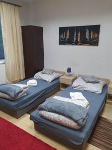 a room with two beds and a red carpet at Pokoje ze wspólną łazienką i kuchnią w centrum Starachowic in Starachowice
