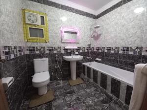 een badkamer met een wastafel, een toilet en een bad bij Hotel rooms overlooking the new museum in Caïro