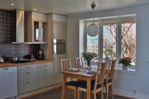 a kitchen with a wooden table and chairs in a kitchen at Captivating Harbor View Suite in Östhammar