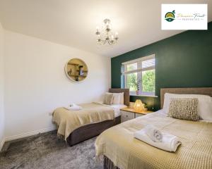 two beds in a room with green walls at LOW Price this winter 3 Bedroom House in Coventry - Sleeps 5 - With Free Unlimited Wi-fi, Driveway & Garden By Passionfruit Properties- 26WWC in Coventry