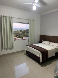 - une chambre avec un lit et une grande fenêtre dans l'établissement CASA UTOPIA ESCARPAS do LAGO, à Capitólio