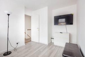 a living room with a couch and a tv on a wall at Lovely and comfortable Home Stay in London in London