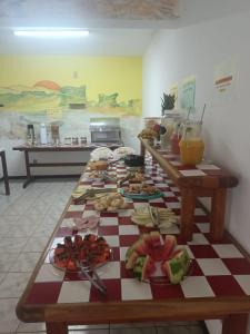 una lunga tavola con diversi tipi di alimenti di BUONA SORTE a Lençóis