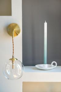 uma lâmpada de vidro num balcão ao lado de uma placa em La Maison Vague em Marselha