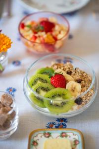 a table topped with a bowl of fruit and cereal at La Maison Vague - Guest House in Marseille